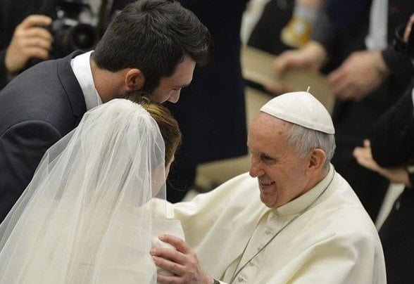 El Papa Francisco saluda a dos recién casados.