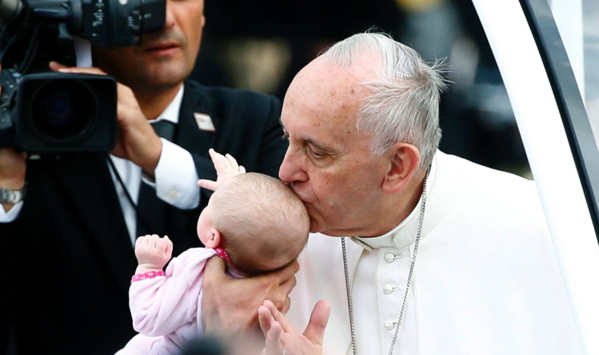 El Papa Francisco besa a un niño. 