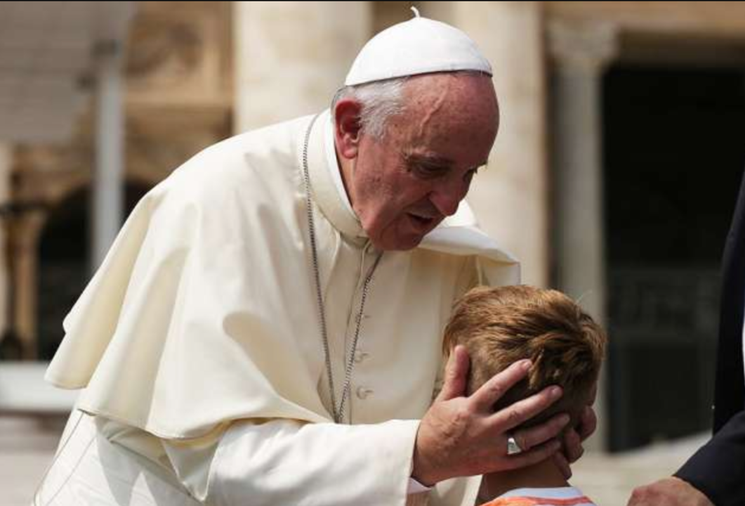El Papa Francisco besa a un niño. 