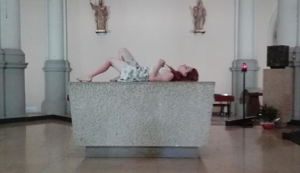 La turista tumbada en el altar de la parroquia de Sant Miquel del Port, en la Barceloneta.