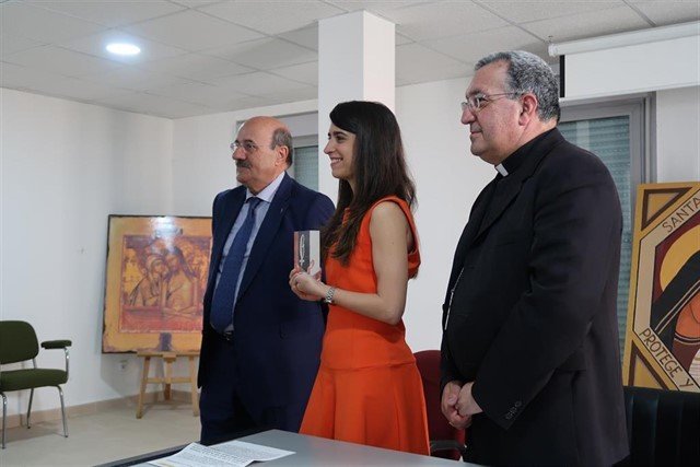 Rafael Ortega, presidente de UCIP-E y mons. Ginés García Beltrán, entregan el premio a Laura Ramírez.