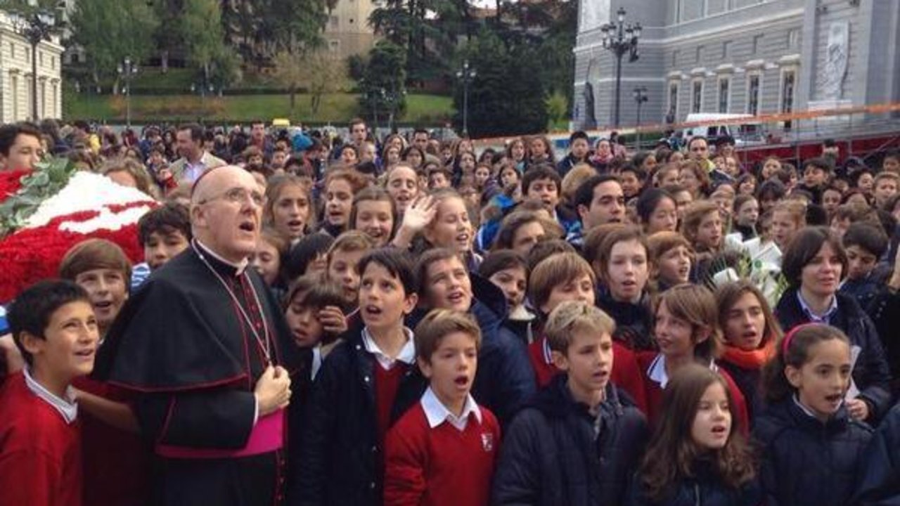 Carlos Osoro junto a un grupo de niños a las puertas de la Catedral de la Almudena. 