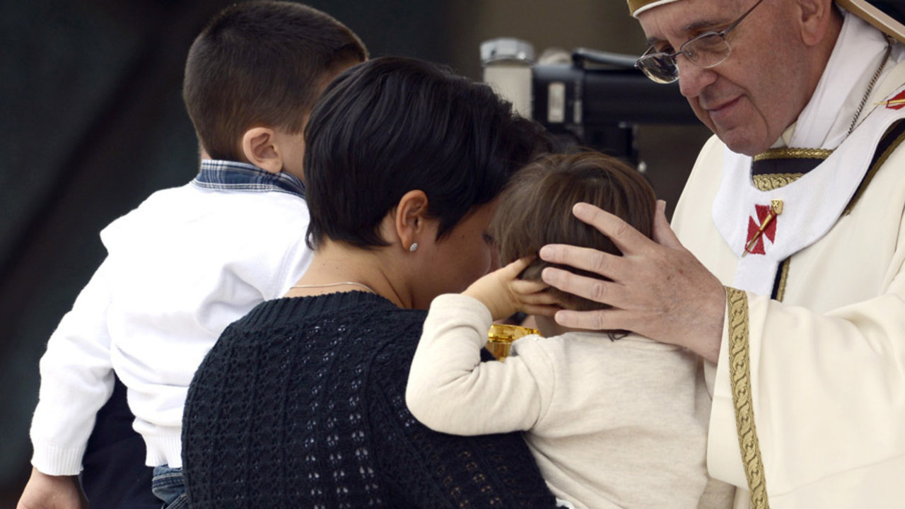 El Papa Francisco, con una madre con dos niños.