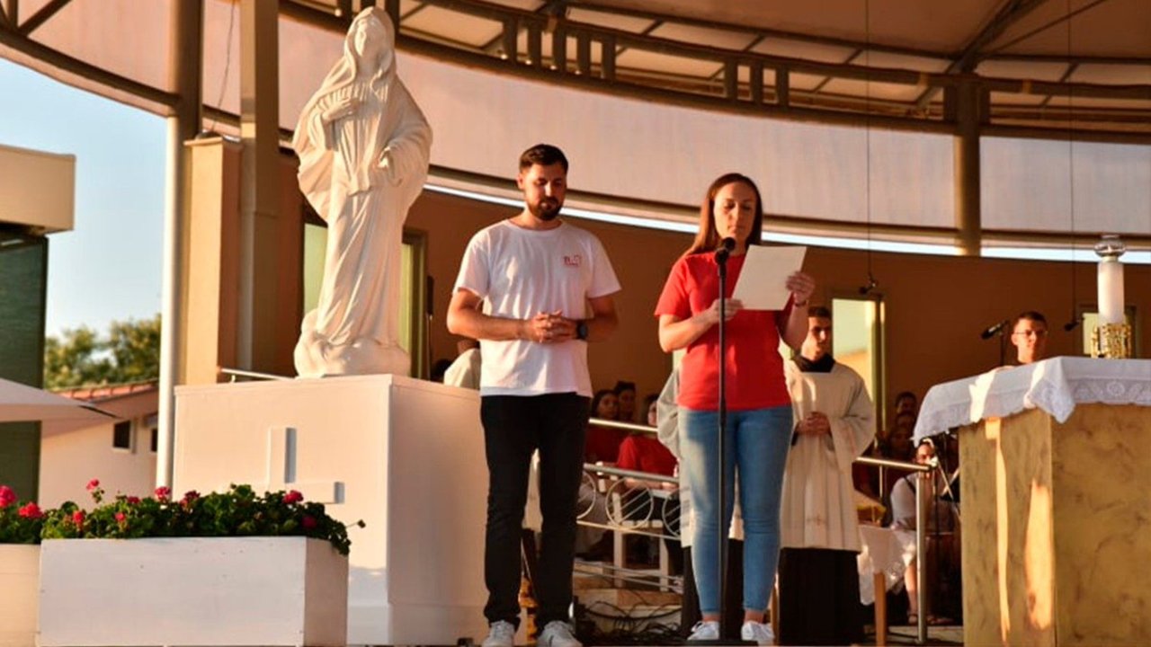 Dos jóvenes leen el mensaje del Papa Francisco en Medjugorje. 