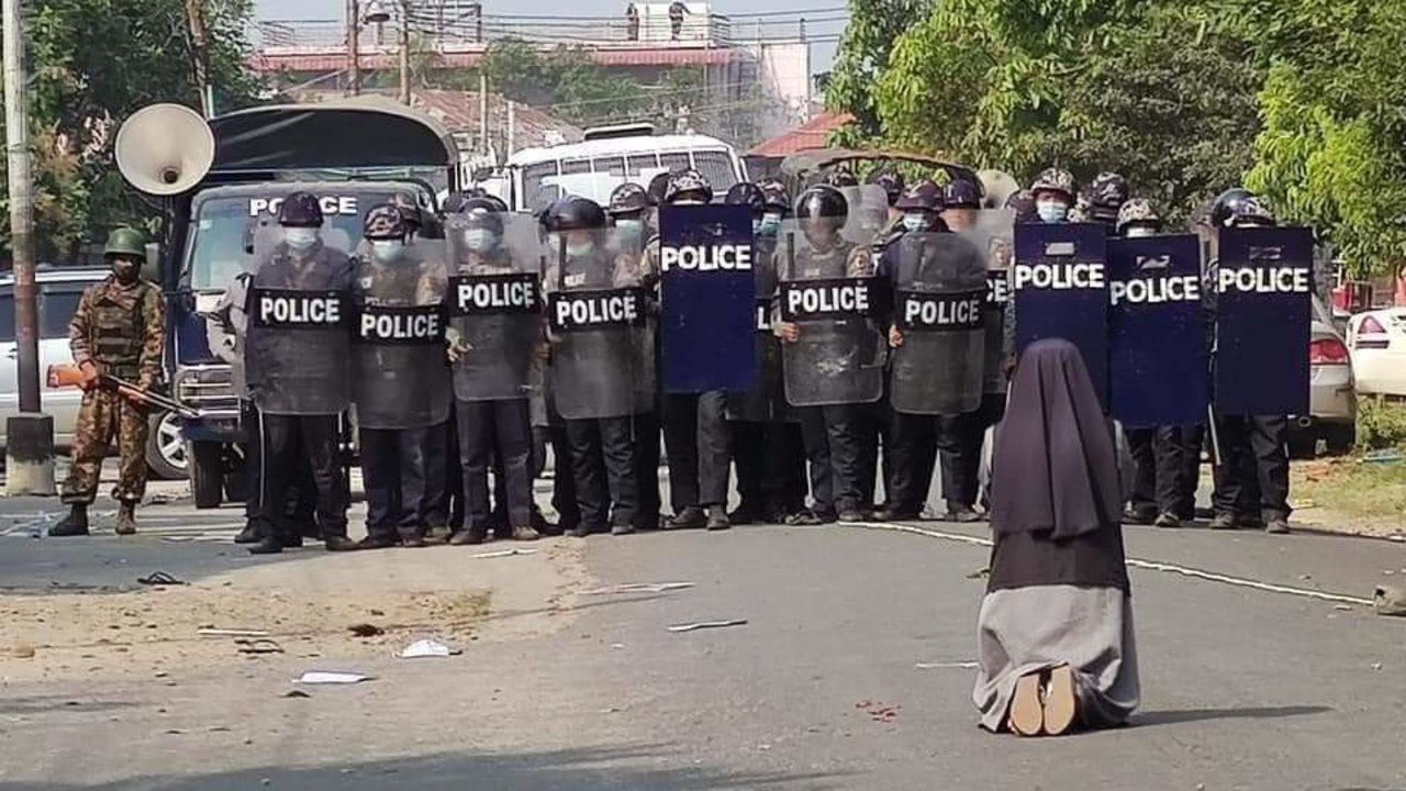 Una monja de Birmania, rezando frente a la policía. 